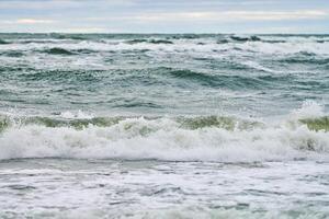 mare blu con onde spumeggianti e cielo nuvoloso, vista sul mare foto