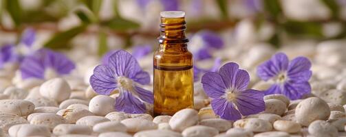 essenziale olio bottiglia con viola fiori su ciottolo surfac foto