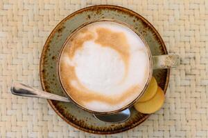 tazza di latte macchiato caffè e cucchiaio su grigio contatore 2 foto