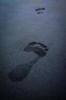 suole di piedi, impronte su il spiaggia sabbia foto