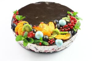 kiev, Ucraina cioccolato torta decorato con mirtilli, biscotti e bolla cioccolatini su un' nero sfondo. Marrone crema formaggio glassa con buio cioccolato gocciola su compleanno torta foto
