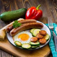 prima colazione fritte uova salsicce zucchine e dolce peperoni foto