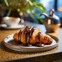 un' brioche su un' piatto coperto nel cioccolato nel un' bar foto