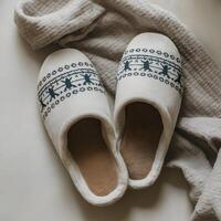 bianca pantofole con nordico modelli evocare calore e comfort su leggero superficie per sociale media inviare dimensione foto