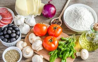 ingredienti per la pizza sullo sfondo in legno foto