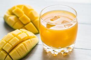 Mango succo su il di legno tavolo foto