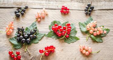 fresco ribes su le foglie su il di legno tavola foto