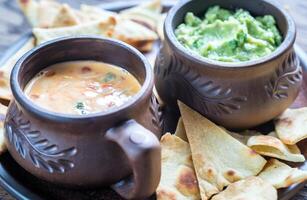 ciotole di guacamole e queso con tortilla chips foto