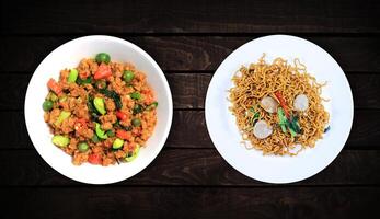 lato piatti, soia verdure e piselli e speziato carne fritte tagliatelle su un' bianca piatto su un' buio di legno sfondo. superiore Visualizza. foto