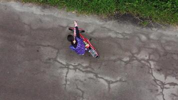 aereo fuco superiore Visualizza volo sopra ragazza cavalcate bicicletta su campagna strada foto