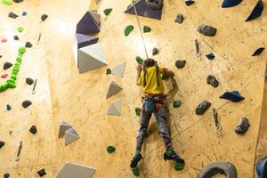 bouldering, poco ragazza arrampicata su il parete foto