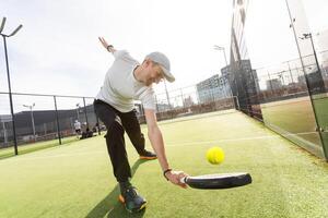 europeo uomo Tenere padel racchetta nel mano e pronto per ritorno palla mentre giocando nel Tribunale foto