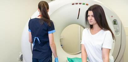 radiologo con un' femmina paziente nel il camera di calcolato tomografia. foto