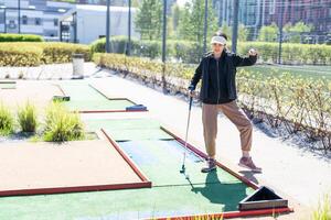 carino poco ragazza su un' miniatura golf corso. foto