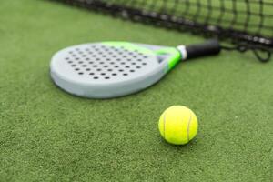 giallo palle su erba torba vicino padel tennis racchetta dietro a netto nel verde Tribunale all'aperto con naturale illuminazione. pagaia è un' racchetta gioco. professionale sport concetto con copia spazio. foto