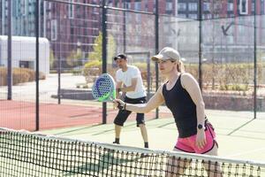 Ucraina kiev, aprile 02 2024. contento atletico coppia avendo divertimento mentre giocando padel tennis raddoppia incontro su all'aperto Tribunale. foto