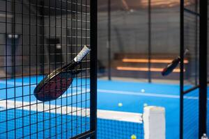 avvicinamento Visualizza di un' pagaia racchetta nel un' padel tennis Tribunale vicino il rete. sport, Salute, gioventù e tempo libero concetto. sportivo attrezzatura. bianca Linee nel sfondo foto