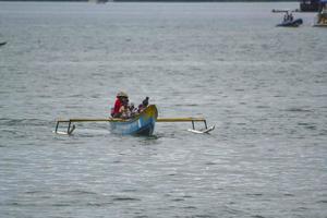 Sorong, Papua occidentale, Indonesia, 2021. Abitante del villaggio che attraversa il mare con una barca di legno. foto