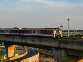 nonthaburi-thailandia aprile 16, 2024 il elettrico cielo treno mrt viola linea passa attraverso centrale porta ovest Dipartimento memorizzare il maggiore shopping plaza nel il sera a scoppio si, nonthaburi Tailandia. foto