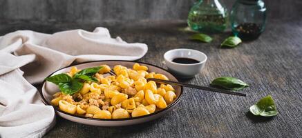 delizioso pasta con tritato carne e basilico su un' piatto su il tavolo ragnatela bandiera foto