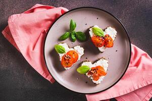 vicino su di crostini su segale pane nel il forma di un' cuore con ricotta e pomodori superiore Visualizza foto