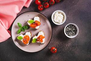 appetitoso crostini su segale pane nel il forma di un' cuore con ricotta e pomodori superiore Visualizza foto