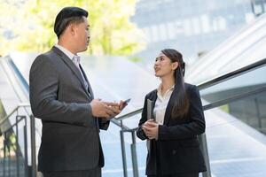 Due professionisti nel conversazione al di fuori un' moderno ufficio edificio foto