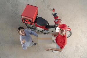consegna servizio giù le mani, motocicletta Corriere dando pacchetto per cliente foto