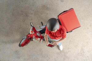 consegna ciclista con rosso scooter in attesa ordini foto