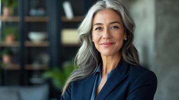 professionale maturo donna d'affari con grigio capelli nel moderno ufficio ambientazione aziendale ritratto per diversità e comando concetti foto