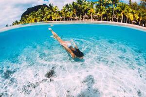 giovane attraente donna nuoto subacqueo nel trasparente blu oceano a mauritius foto