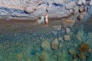 apneista donna con pinne in posa su mare costa. aereo Visualizza foto