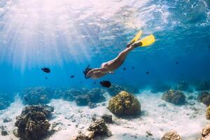 donna apneista nuoto al di sopra di con giallo pinne nel oceano. apnea o lo snorkeling nel mauritius foto