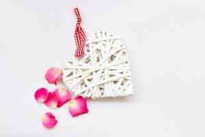 decorativo bianca cuore fatto di viti, San Valentino giorno su il sfondo di un' mazzo di Rose. foto