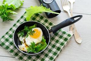 fritte uovo nel un' frittura padella con erbe aromatiche foto