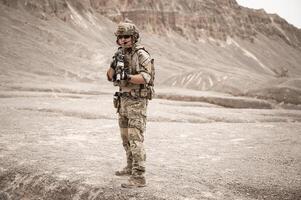 soldati nel camuffare uniformi mirando con loro fucili pronti per fuoco durante militare operazione nel il deserto soldati formazione nel un' militare operazione foto