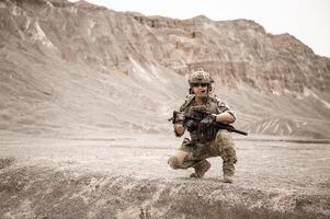 soldati nel camuffare uniformi mirando con loro fucili pronti per fuoco durante militare operazione nel il deserto soldati formazione nel un' militare operazione foto