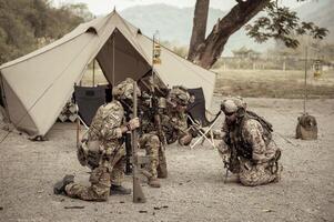 soldati nel camuffare uniformi pianificazione su operazione nel il campo foto