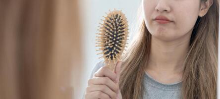 asiatico donna molto triste e irritato guardare a danneggiato capelli, capelli perdita, capelli diradamento problema, vitamina carenza, calvizie, postpartum, biotina, zinco, mestruale o endocrino disturbi, ormonale squilibrio foto