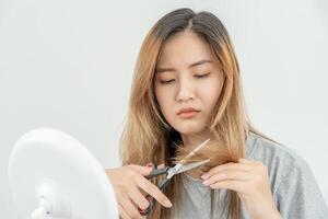 asiatico donna molto triste e irritato guardare a danneggiato capelli, capelli perdita, capelli diradamento problema, vitamina carenza, calvizie, postpartum, biotina, zinco, mestruale o endocrino disturbi, ormonale squilibrio foto