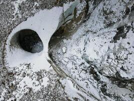 aereo. un ghiaccio arco formato di il fusione di un' ghiacciaio. ghiaccio grotta foto