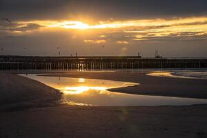 tramonto su spiaggia con un' di legno frangiflutti nel leba, baltico mare, Polonia foto