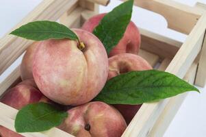 un' di legno gabbia pieno con Pesche foto