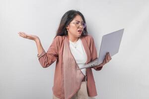 confuso asiatico attività commerciale donna Tenere il computer portatile pensiero di stressante opera carico, isolato al di sopra di bianca sfondo. foto