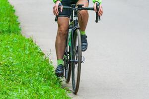 ciclista su il asfalto strada nel il parco foto