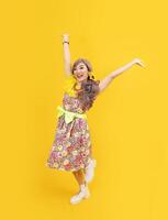 asiatico hippie donna vestito nel anni 80 Vintage ▾ moda con colorato retrò capi di abbigliamento mentre danza isolato su giallo sfondo per fantasia attrezzatura festa e pop cultura concetto foto