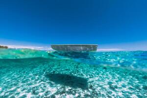 tropicale turchese oceano acqua con sabbioso parte inferiore subacqueo e barca foto