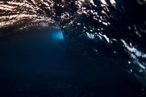 barile onda nel oceano con caldo tramonto o Alba toni. subacqueo sfondo con fare surf onda foto