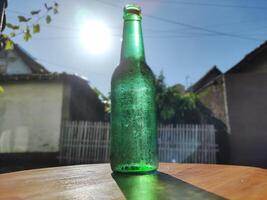 verde bicchiere bottiglia contro luce del sole foto