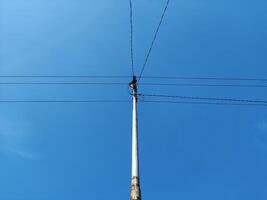 Basso angolo Visualizza di elettricità pilone contro blu cielo foto